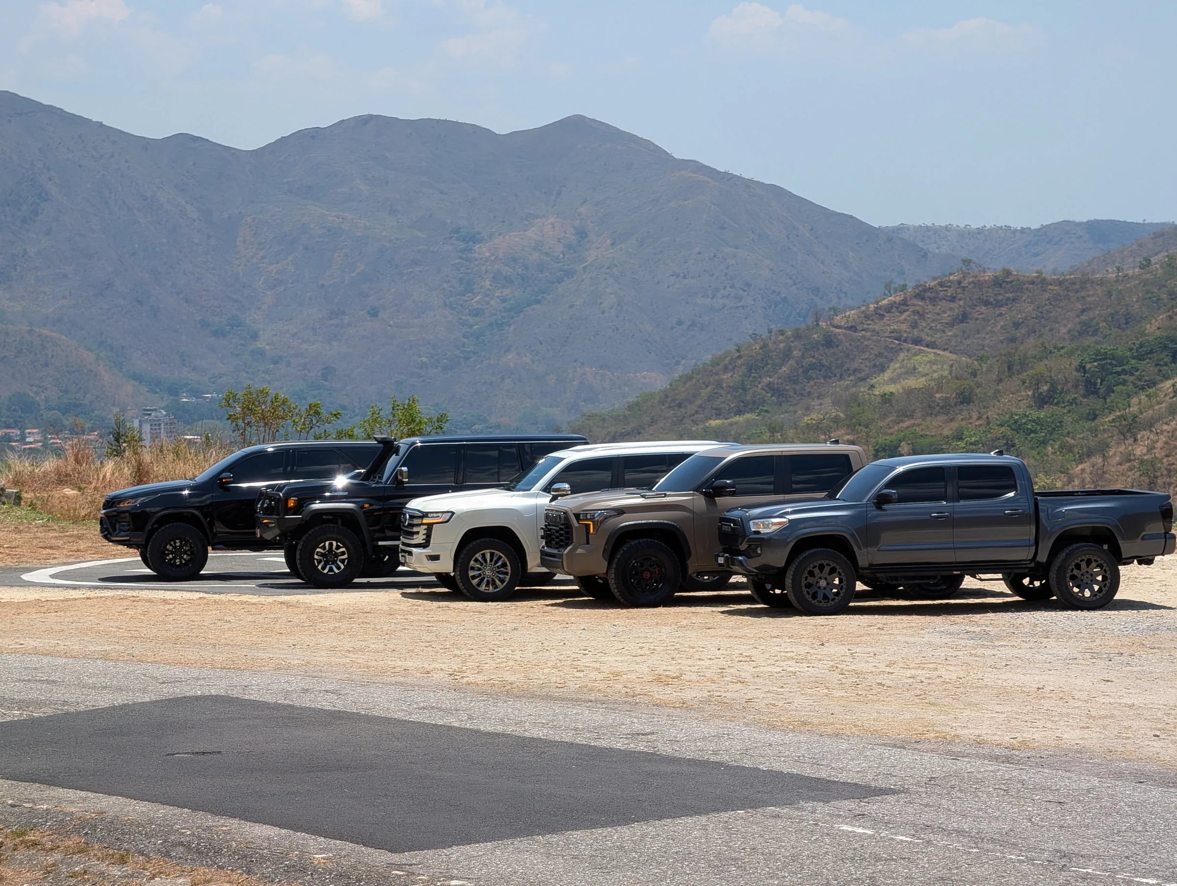 Flota de vehículos preparados por Dacar Motors estacionada en ruta de montaña